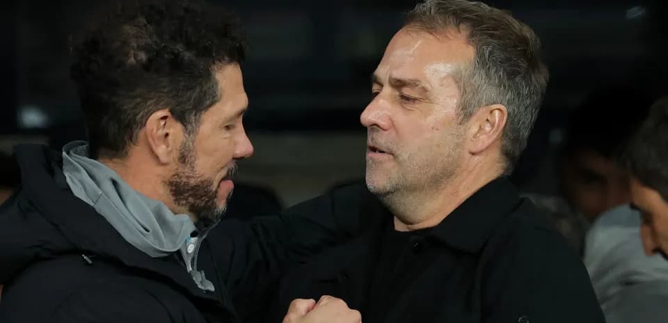 Entrenadores saludándose en el banquillo del partido