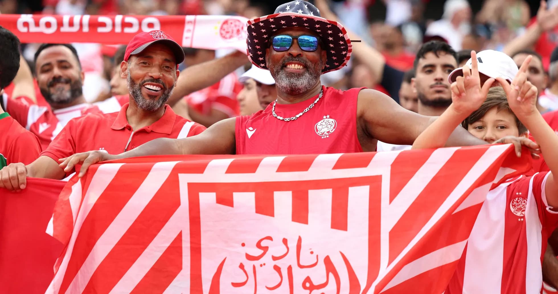 Aficionados sosteniendo una bandera del equipo en el estadio