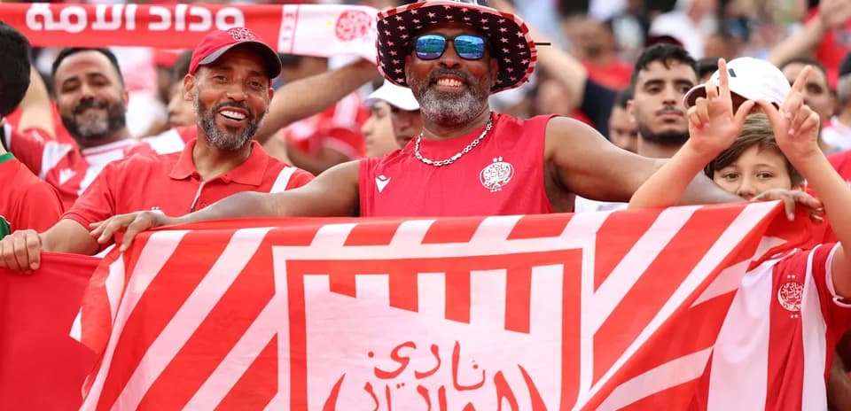 Aficionados sosteniendo una bandera del equipo en el estadio