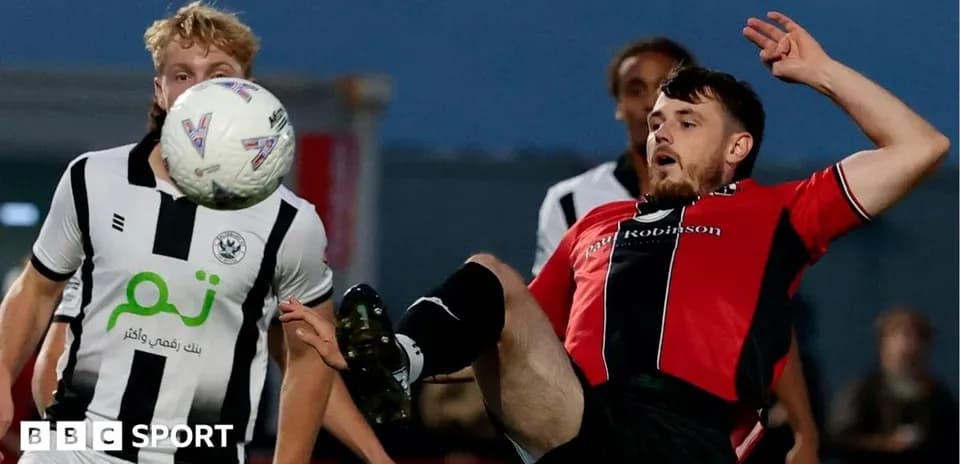 Jugador en el suelo intentando controlar el balón