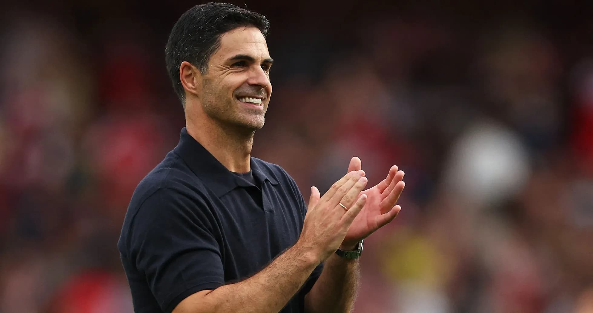 Entrenador aplaudiendo en el campo durante el partido