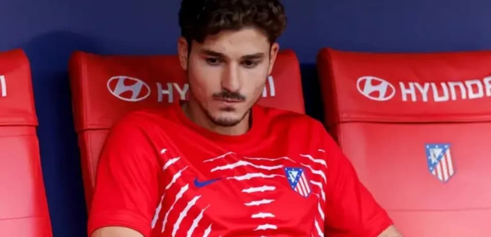 Jugador sentado en el banquillo con camiseta de Atlético