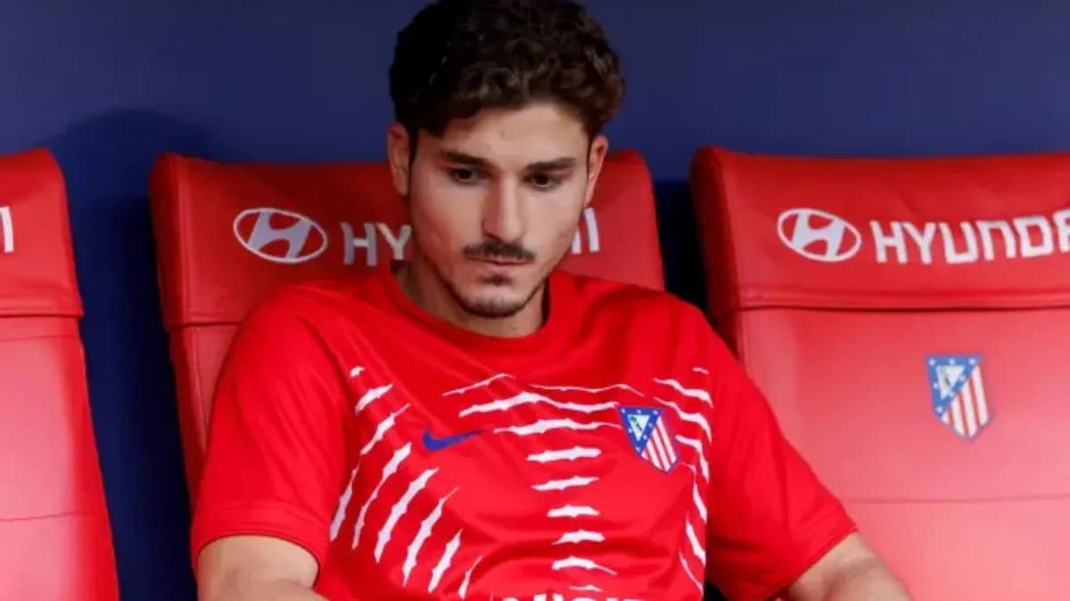 Jugador sentado en el banquillo con camiseta de Atlético