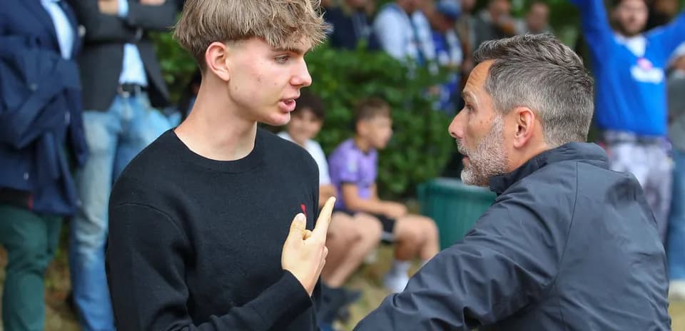 Joven discutiendo con un hombre en un evento deportivo