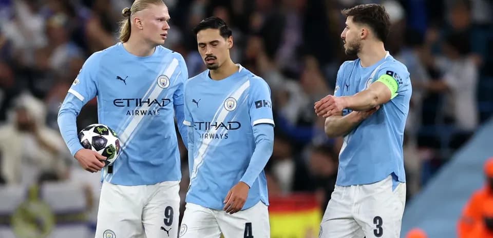 Jugadores de Manchester City con balón en el campo