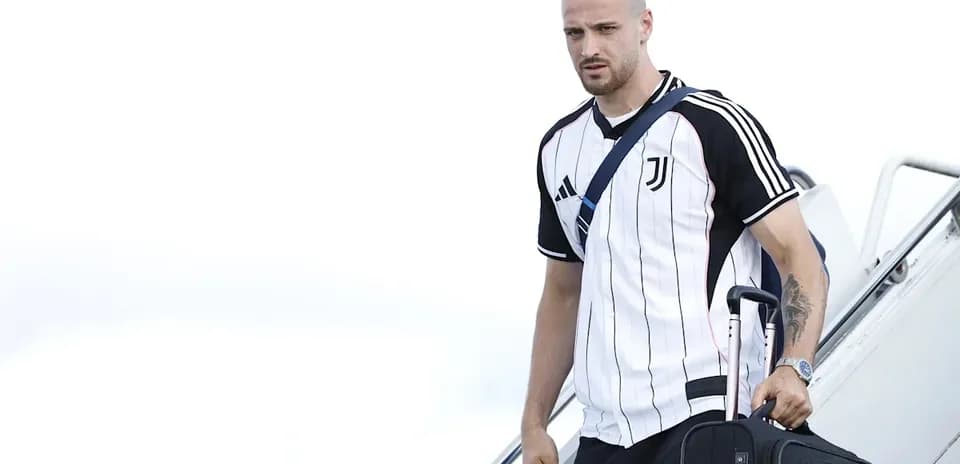 Jugador de Juventus bajando de un avión con maleta