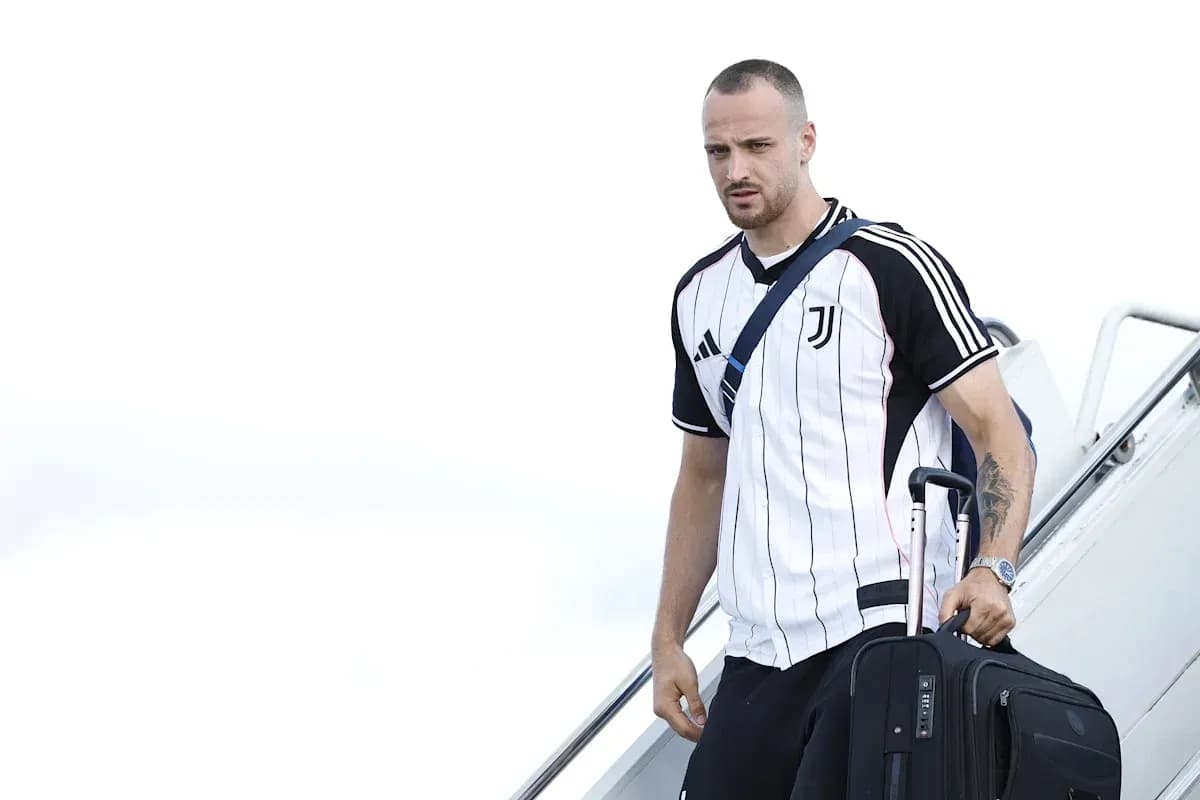 Jugador de Juventus bajando de un avión con maleta