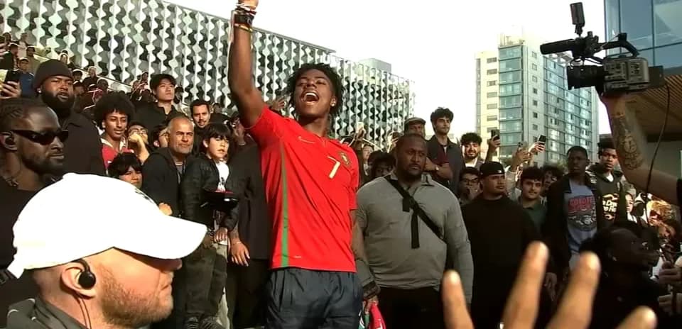 Joven con camiseta de Portugal levantando la mano en un evento