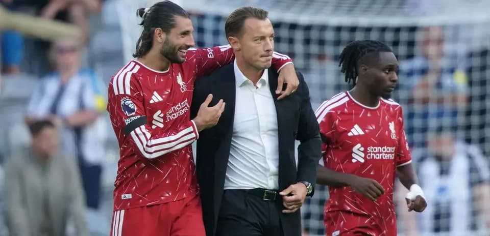Jugadores de Liverpool celebrando con entrenador en el campo