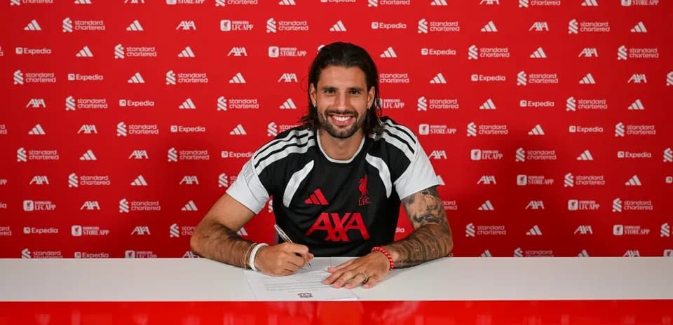 Jugador firmando contrato en mesa de prensa