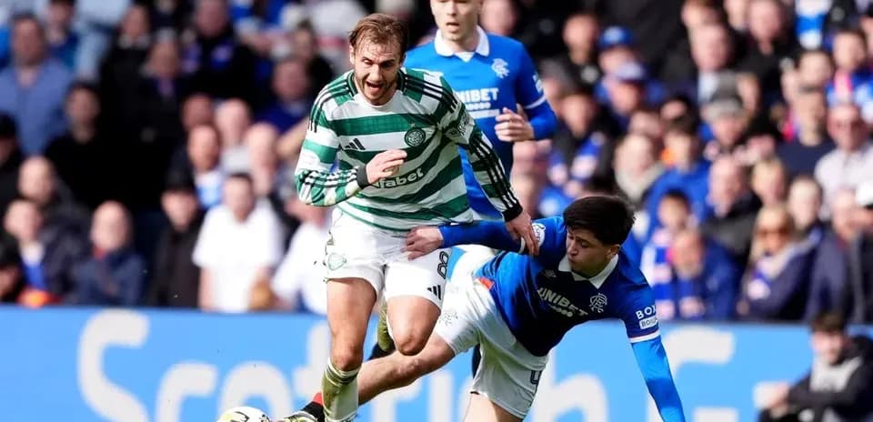 Jugador de Celtic corriendo mientras otro cae al suelo