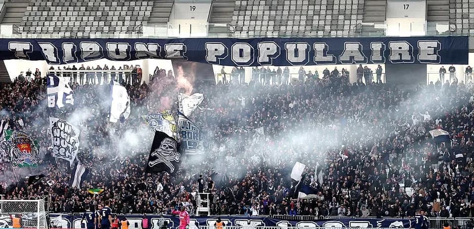 Aficionados animando en el estadio con banderas