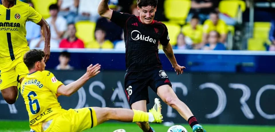 Jugador de Sevilla esquivando a un defensor de Villarreal