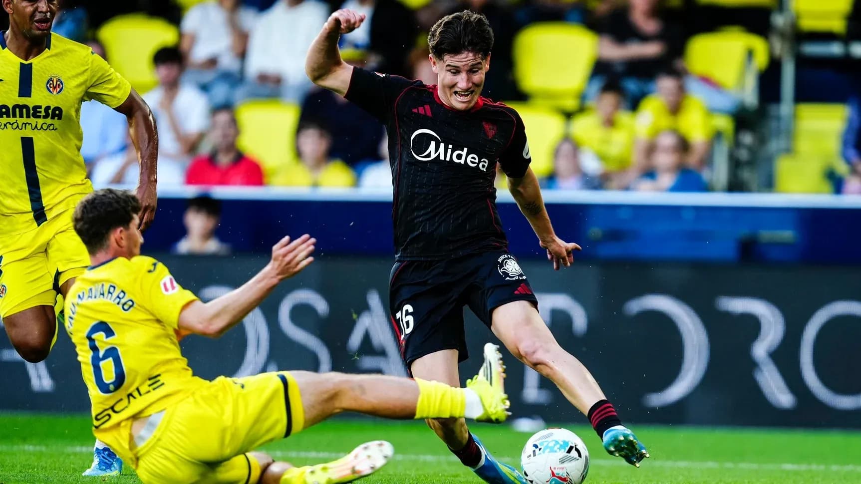 Jugador de Sevilla esquivando a un defensor de Villarreal
