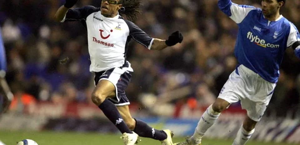 Jugador de Tottenham corriendo con balón, defensor persiguiéndolo