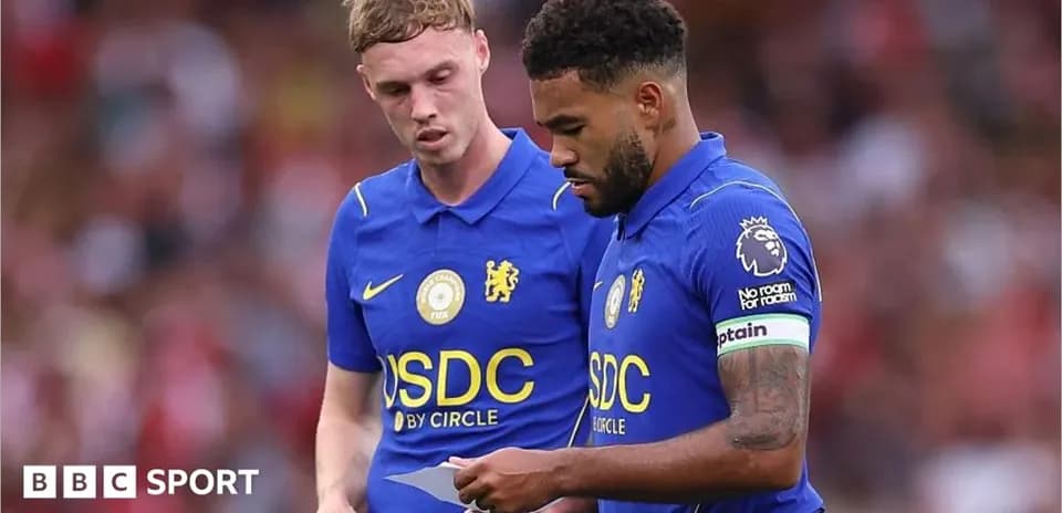 Dos jugadores de Chelsea revisando una hoja durante el partido