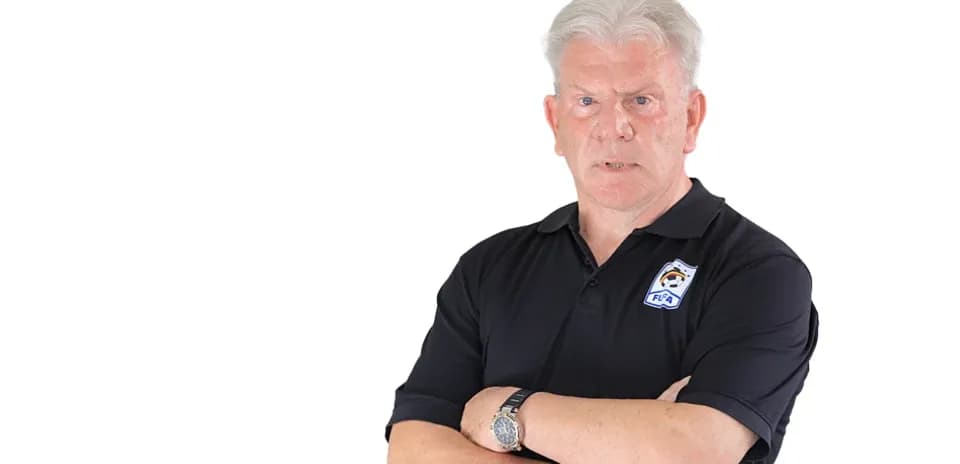 Entrenador con brazos cruzados en camiseta negra