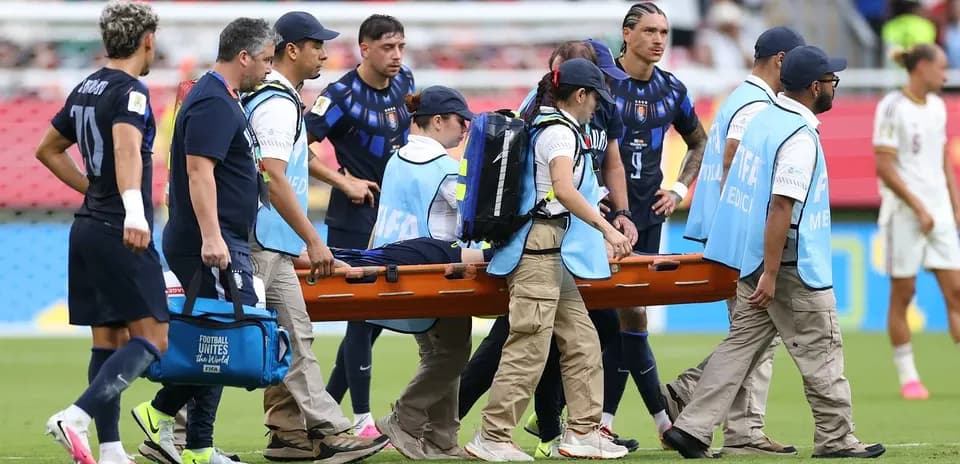 Jugadores y personal médico trasladando a jugador herido