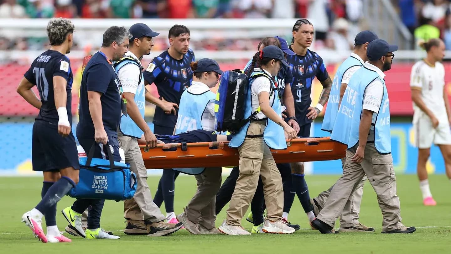 Jugadores y personal médico trasladando a jugador herido