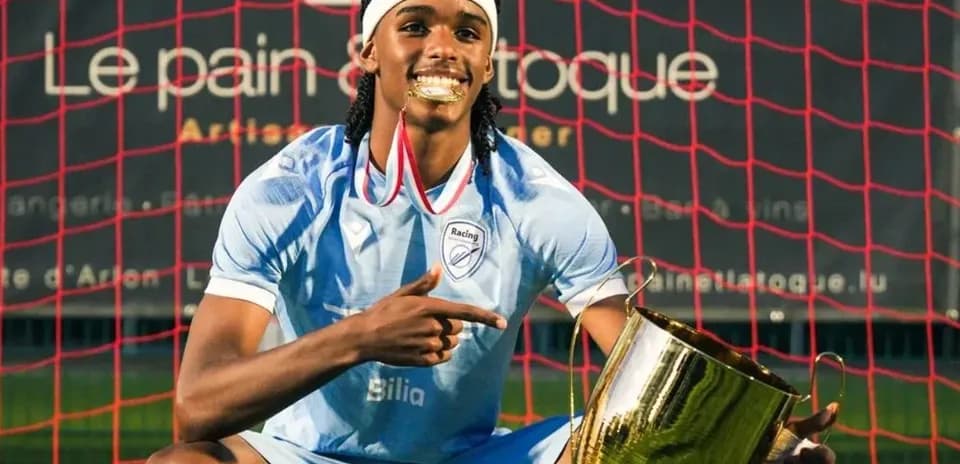 Jugador celebrando con trofeo en el campo de fútbol