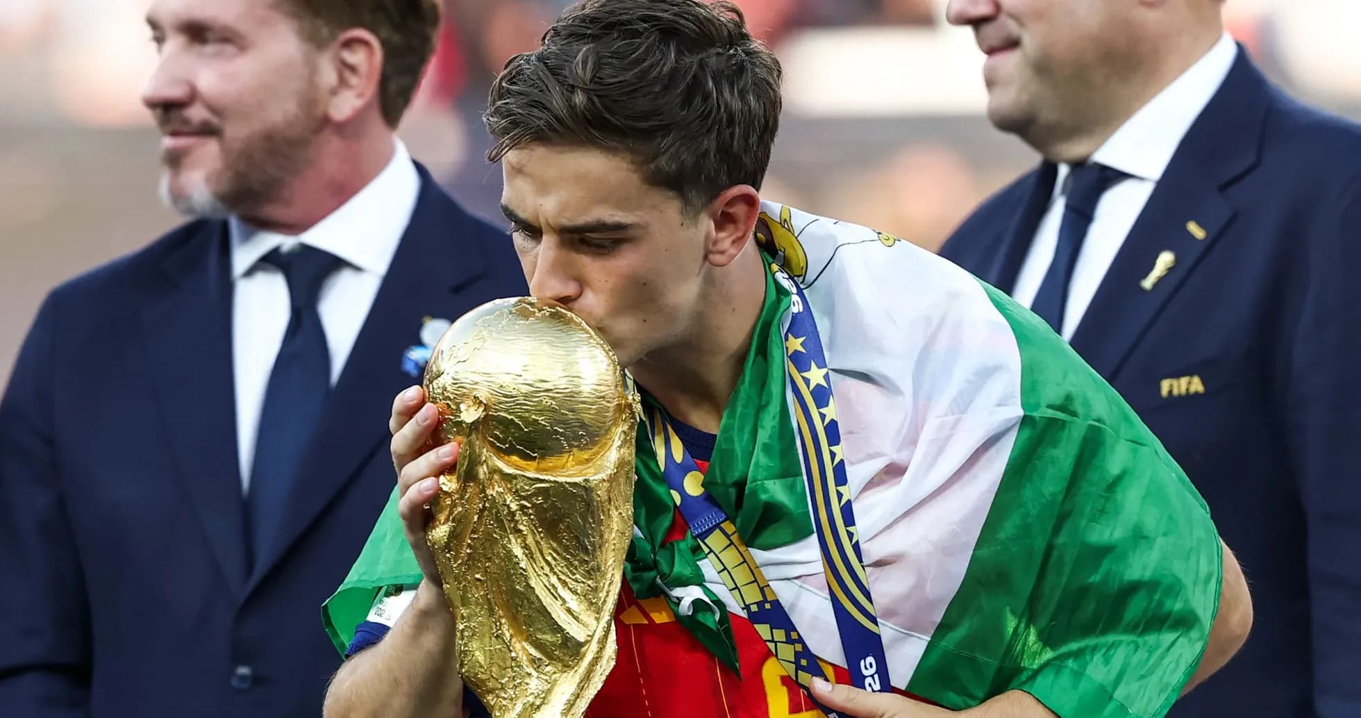 Jugador besando la copa del mundo con bandera
