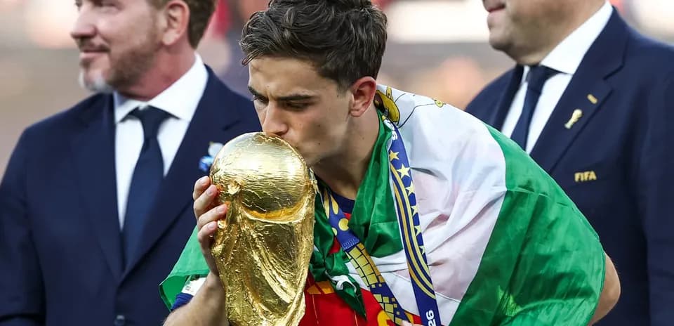 Jugador besando la copa del mundo con bandera
