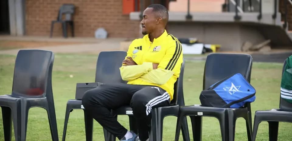Entrenador sentado en la banca de un campo de entrenamiento