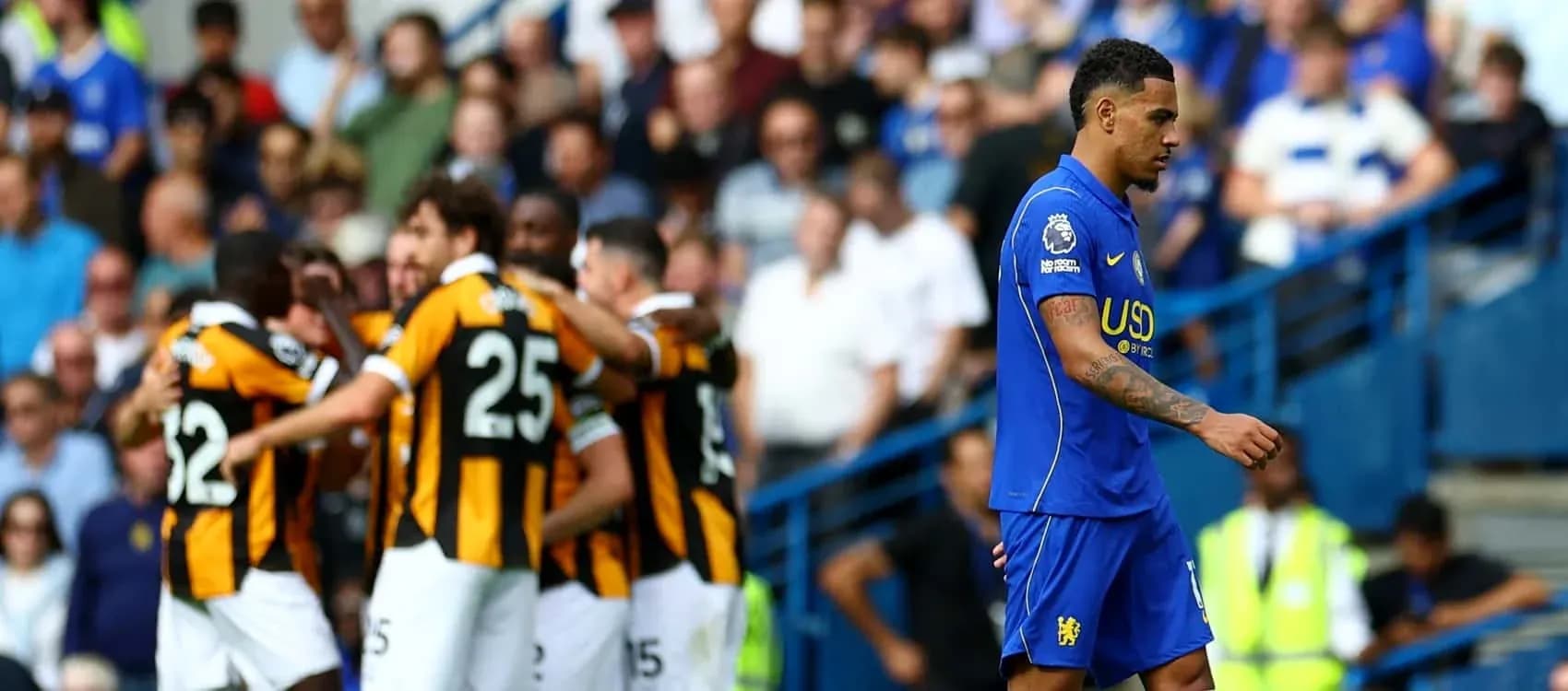 Jugador de Chelsea caminando mientras equipo rival celebra gol