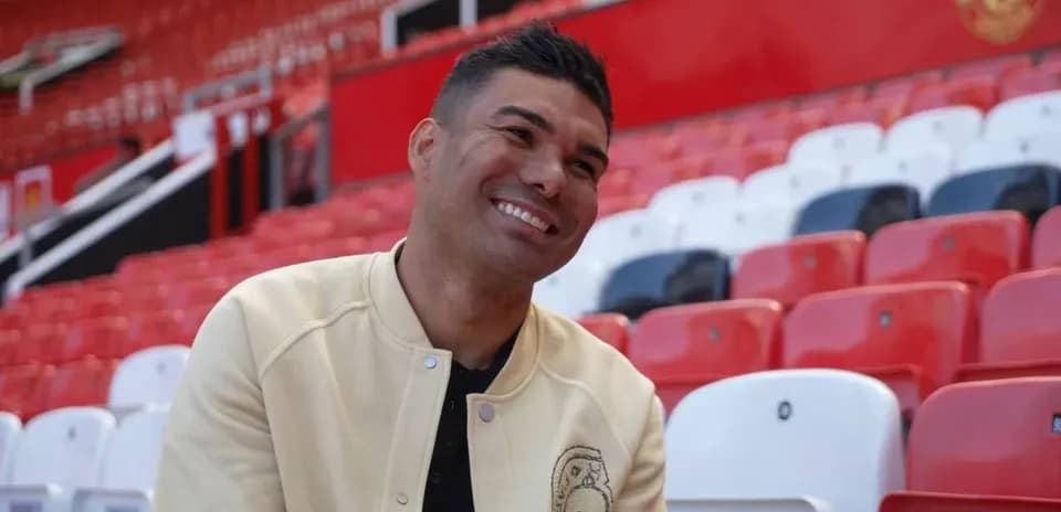 Jugador sonriente sentado en las gradas del estadio