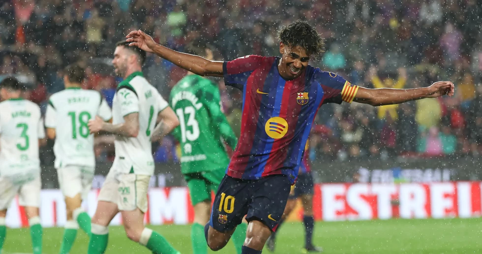 Jugador de Barcelona celebrando un gol bajo la lluvia Jugador de Barcelona celebrando un gol bajo la lluvia