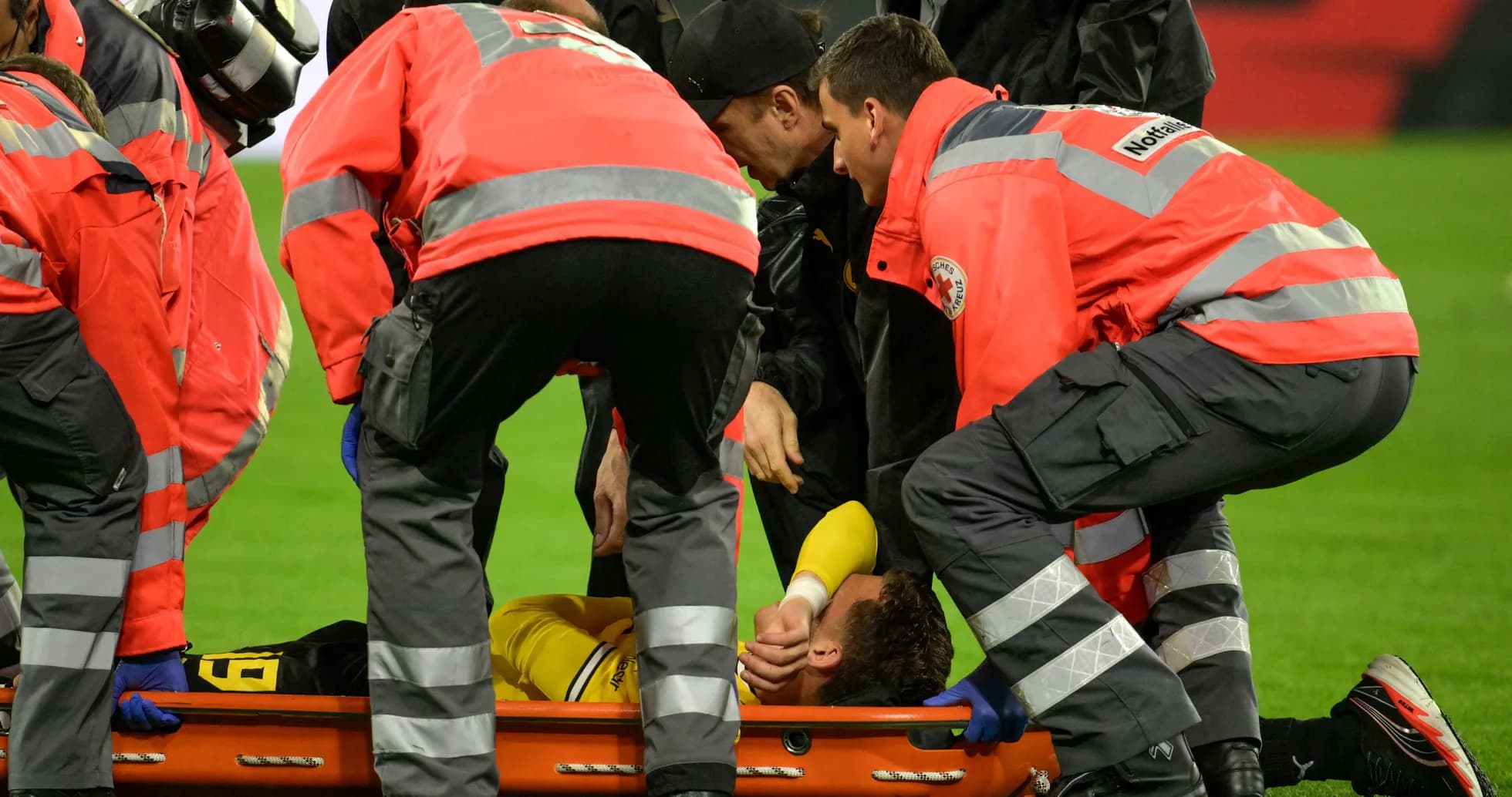 Equipo médico atendiendo a jugador lesionado en campo Equipo médico atendiendo a jugador lesionado en campo