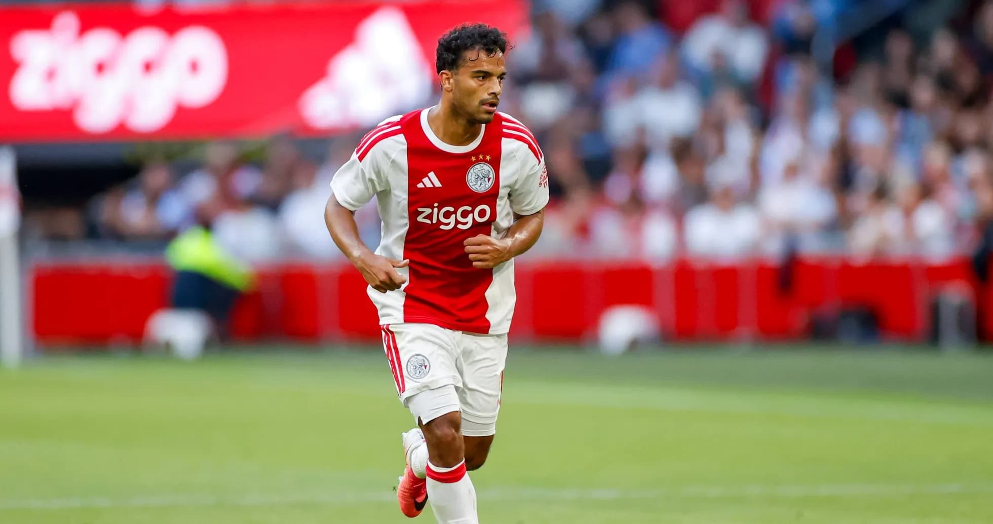 Jugador de Ajax corriendo con el balón en el campo Jugador de Ajax corriendo con el balón en el campo