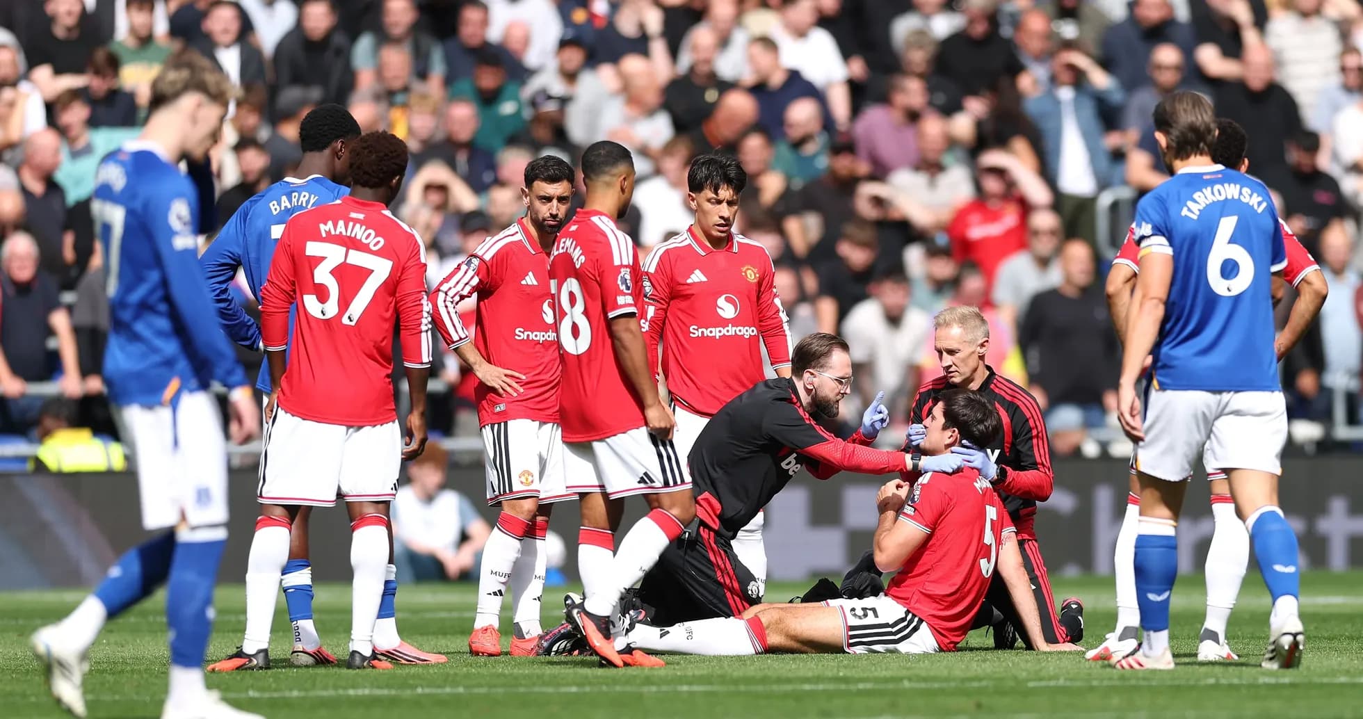 Jugador de Manchester United recibiendo atención médica en el campo Jugador de Manchester United recibiendo atención médica en el campo