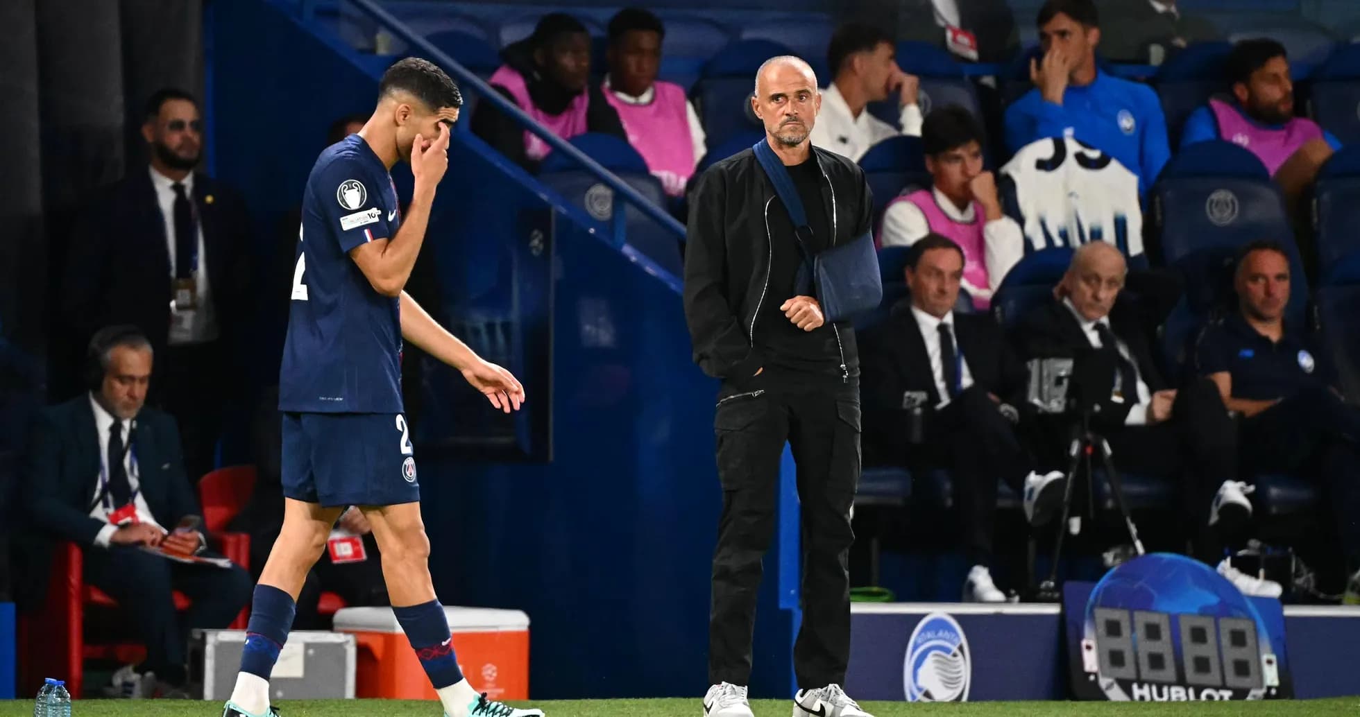 Jugador de PSG saliendo del campo con entrenador observando Jugador de PSG saliendo del campo con entrenador observando