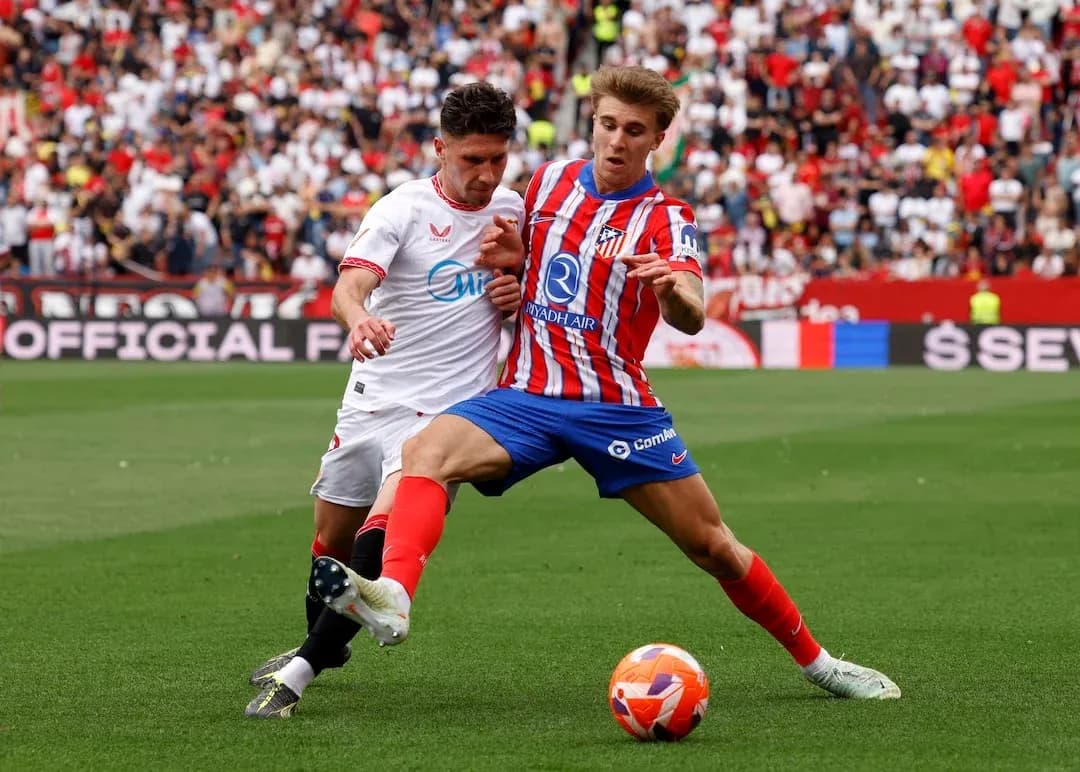 Jugadores de Sevilla y Atlético compitiendo por el balón Jugadores de Sevilla y Atlético compitiendo por el balón