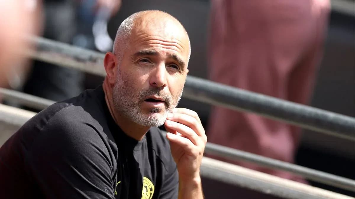 Entrenador observando desde la banca durante el partido Entrenador observando desde la banca durante el partido