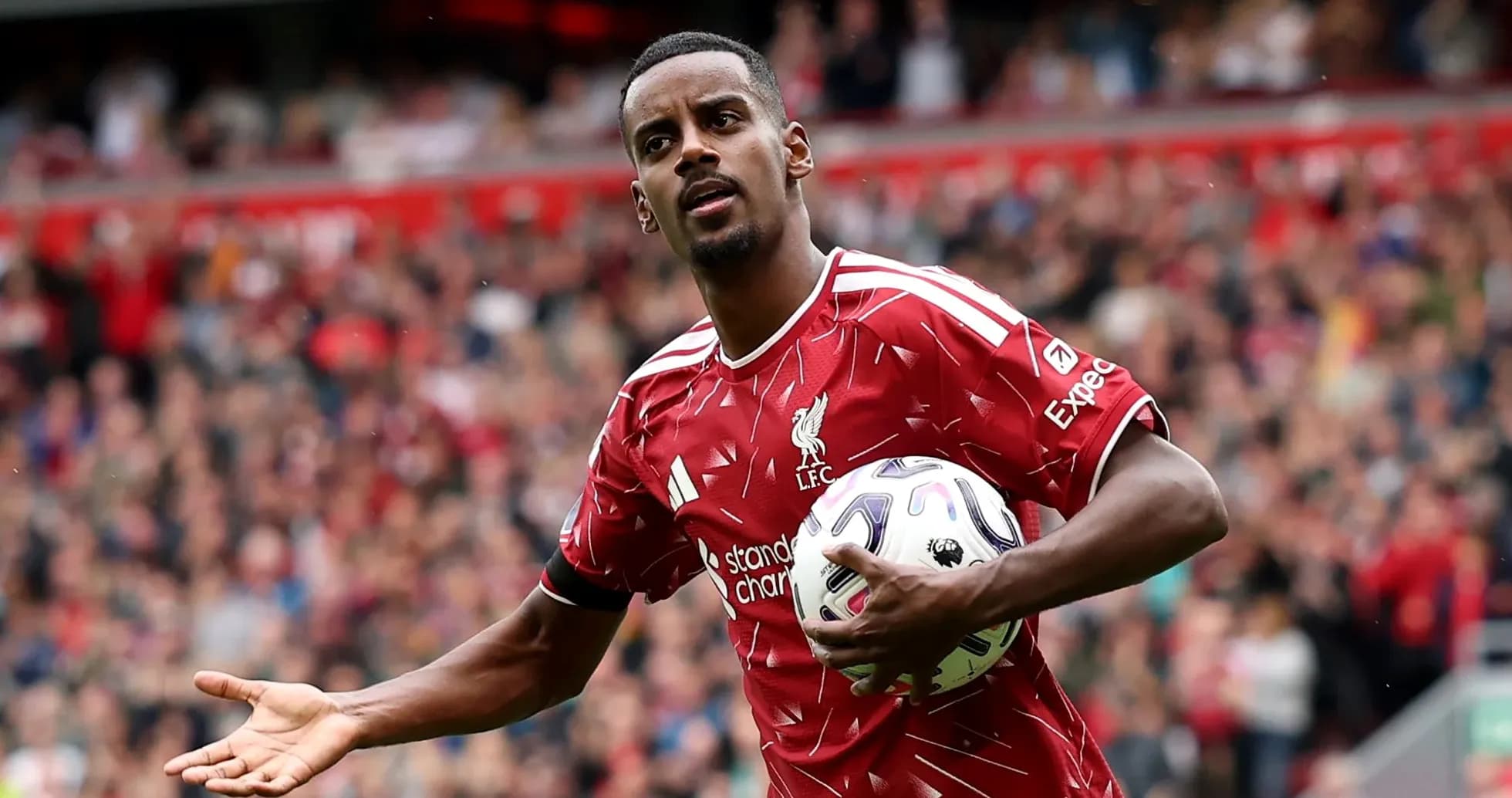 Jugador de Liverpool sosteniendo un balón en el campo Jugador de Liverpool sosteniendo un balón en el campo