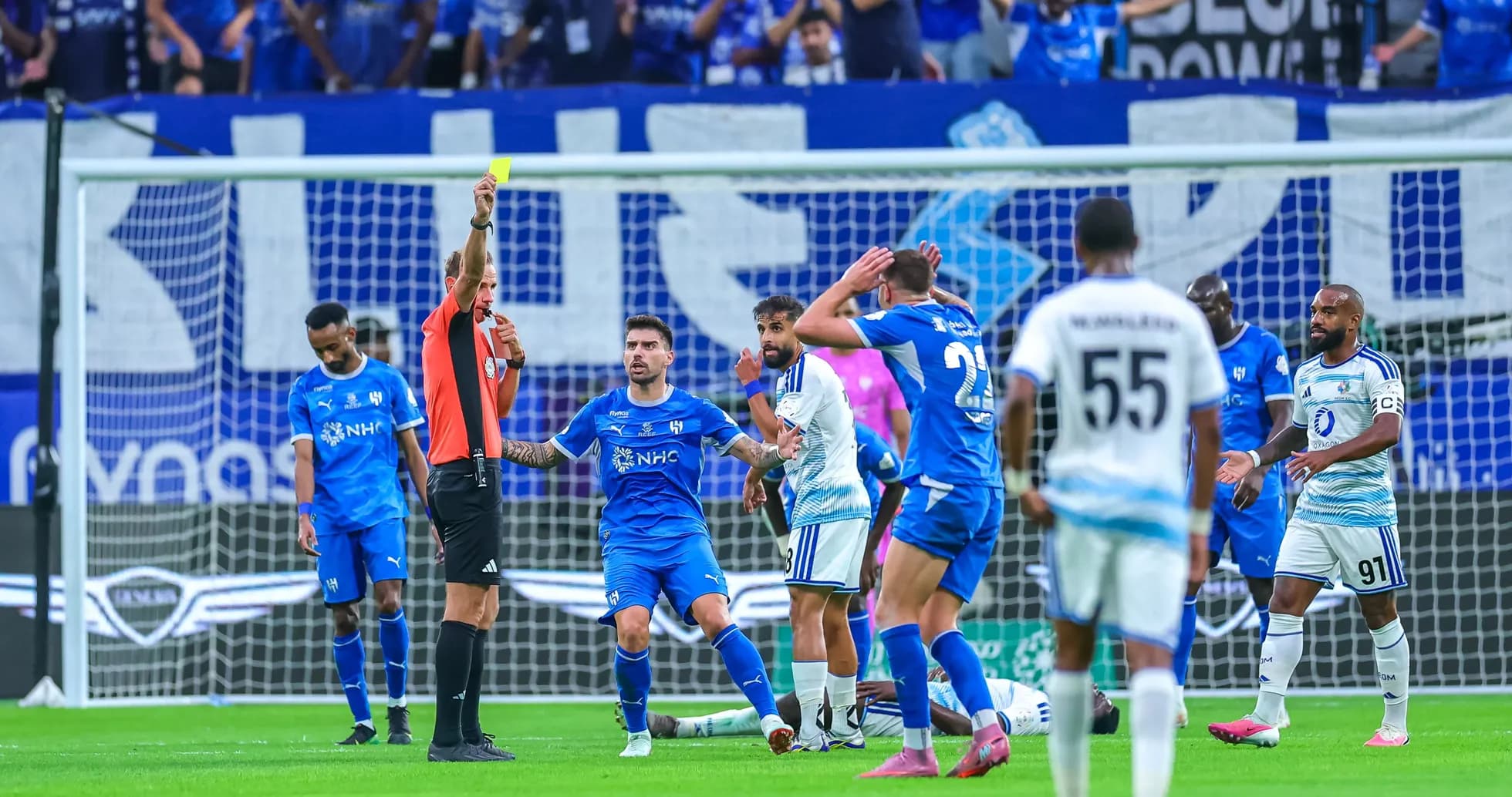 Árbitro muestra tarjeta amarilla a jugador durante partido Árbitro muestra tarjeta amarilla a jugador durante partido