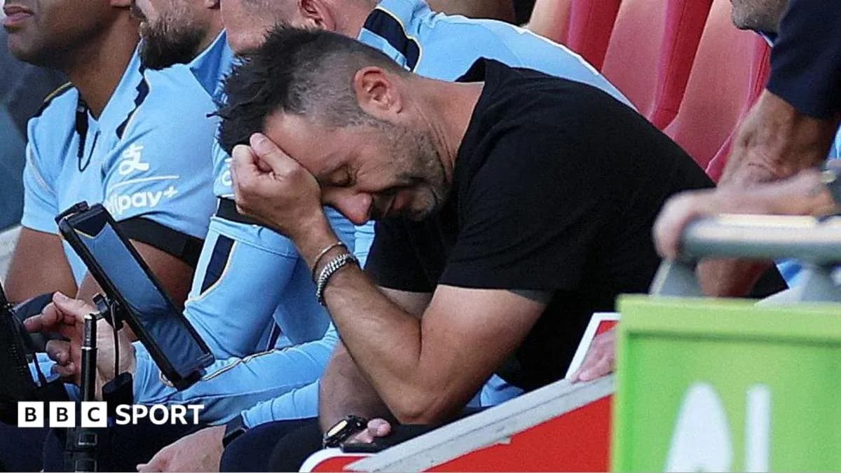 Entrenador con la cabeza entre las manos en el banquillo Entrenador con la cabeza entre las manos en el banquillo