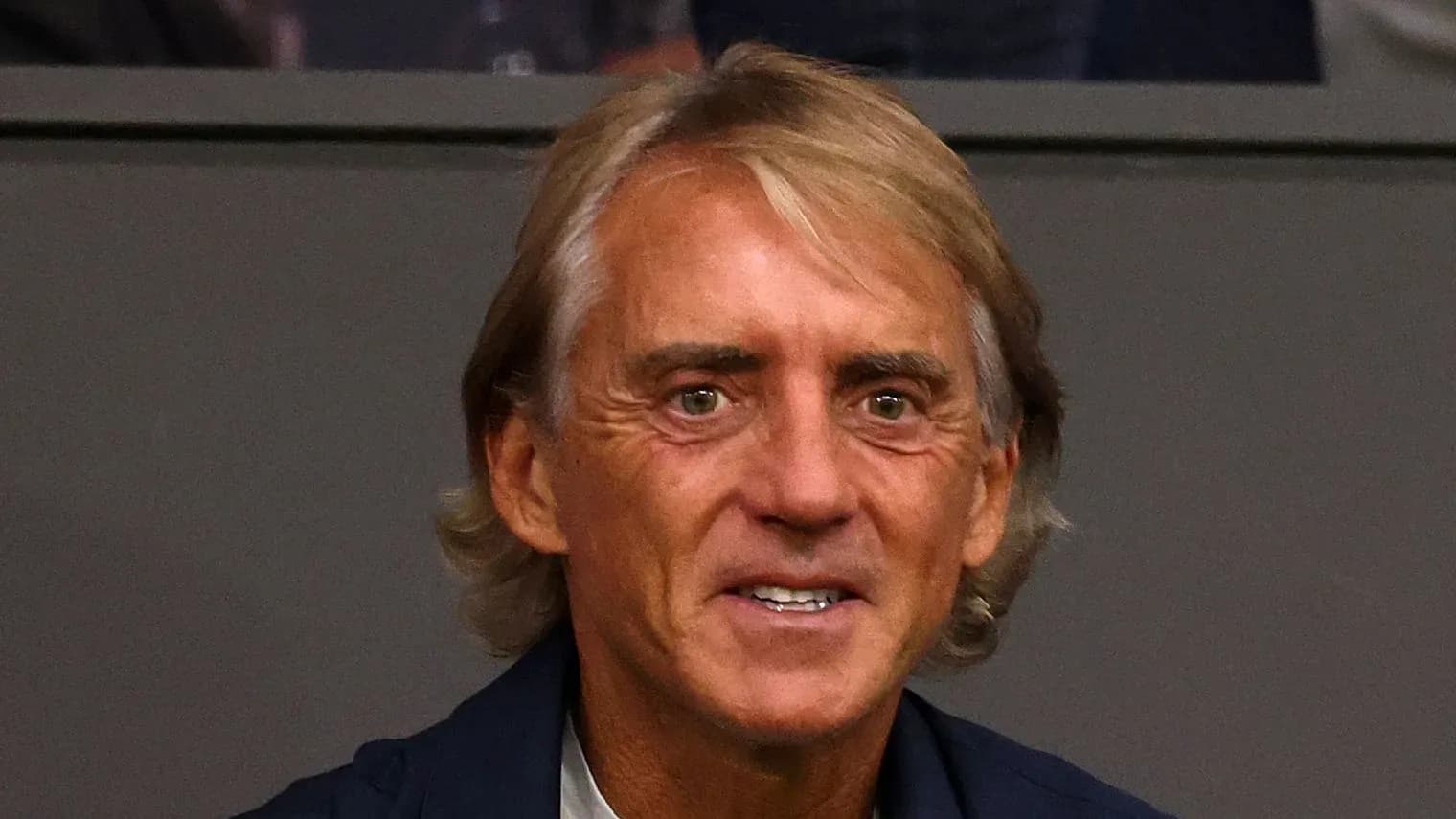 Hombre sonriendo en un entorno deportivo Hombre sonriendo en un entorno deportivo