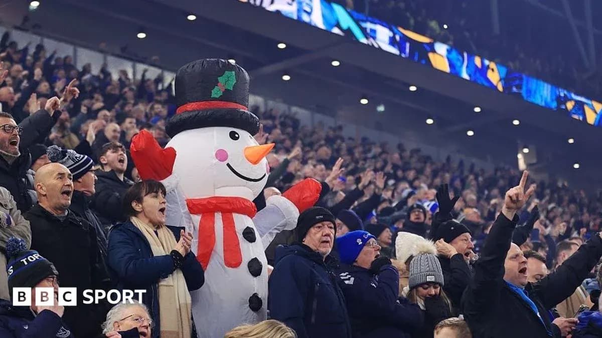 A large snowman costume among cheering fans A large snowman costume among cheering fans