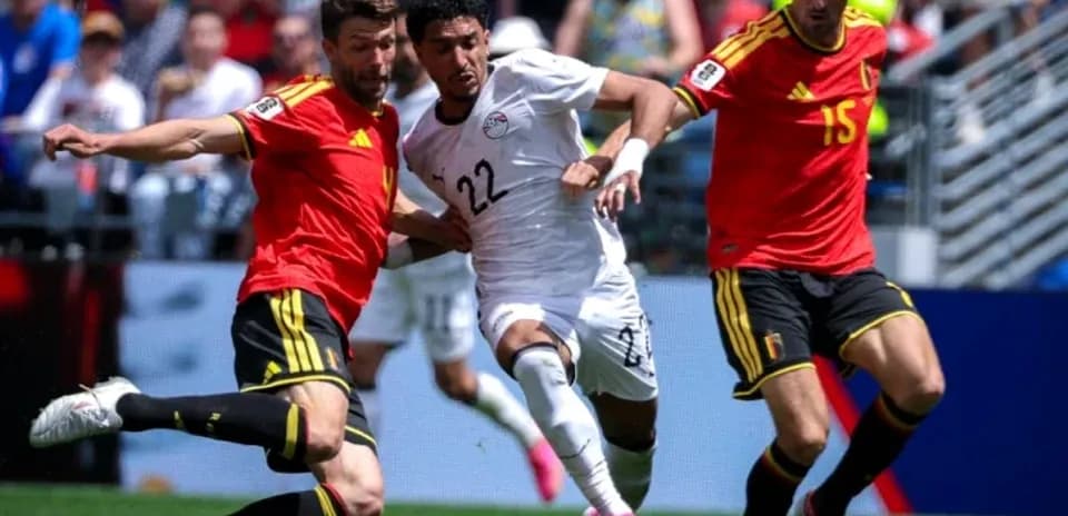 Jugador de Egipto luchando por el balón contra dos de Bélgica Jugador de Egipto luchando por el balón contra dos de Bélgica