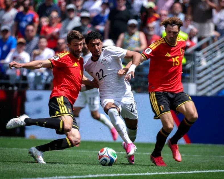 Jugador de Egipto luchando por el balón contra dos de Bélgica Jugador de Egipto luchando por el balón contra dos de Bélgica