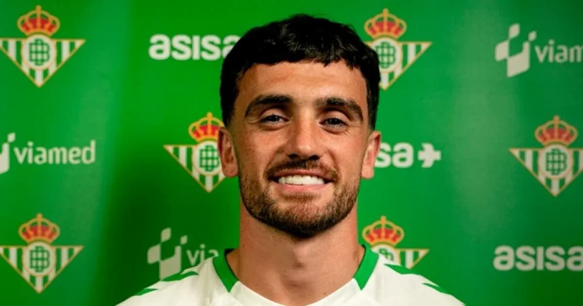 Jugador sonriente frente a fondo del Real Betis Jugador sonriente frente a fondo del Real Betis