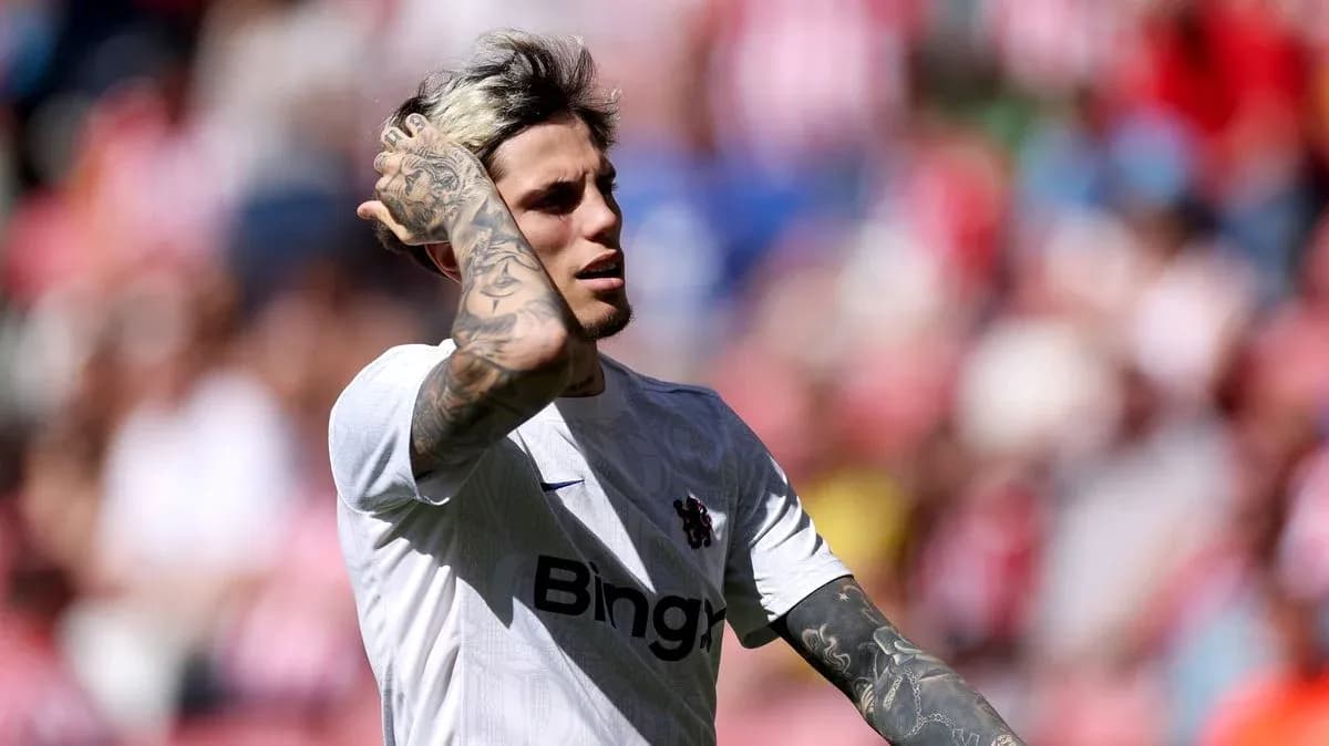 Jugador con camiseta blanca tocándose el cabello en el campo Jugador con camiseta blanca tocándose el cabello en el campo