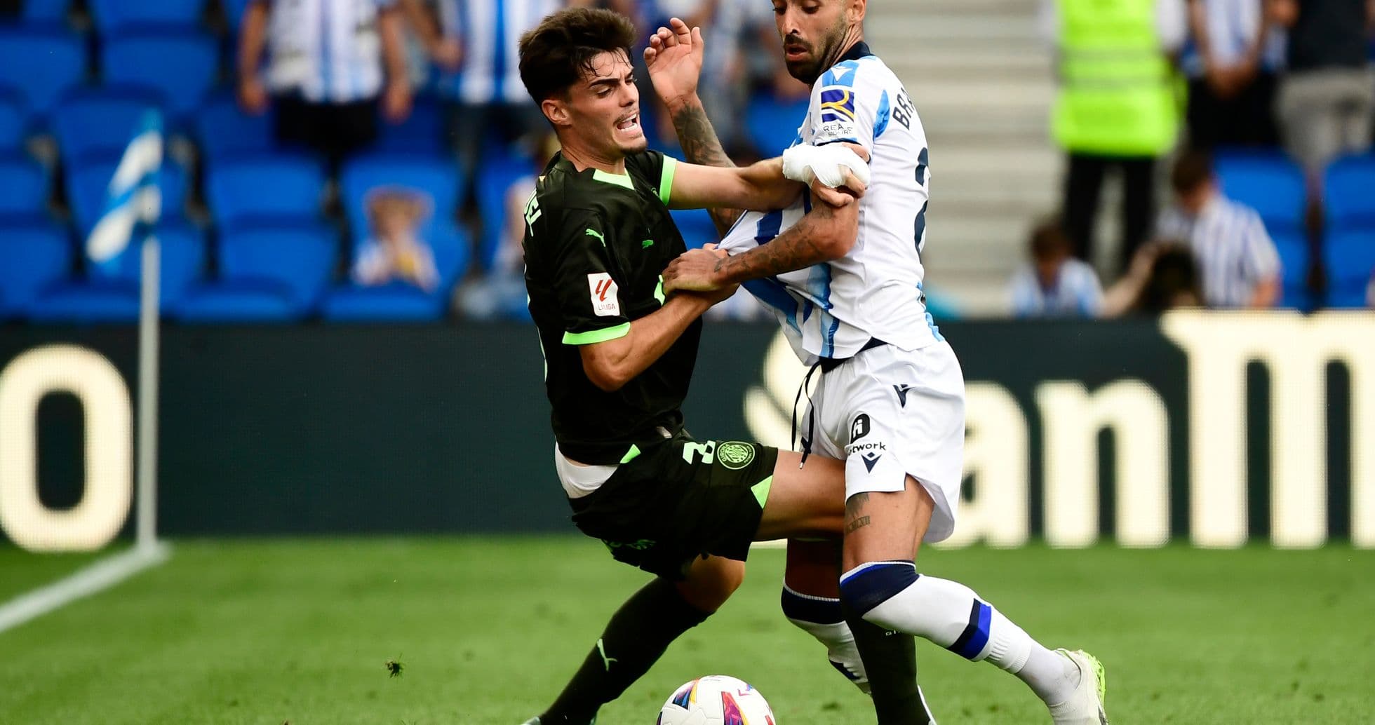 Dos jugadores compitiendo por el balón en La Liga Dos jugadores compitiendo por el balón en La Liga