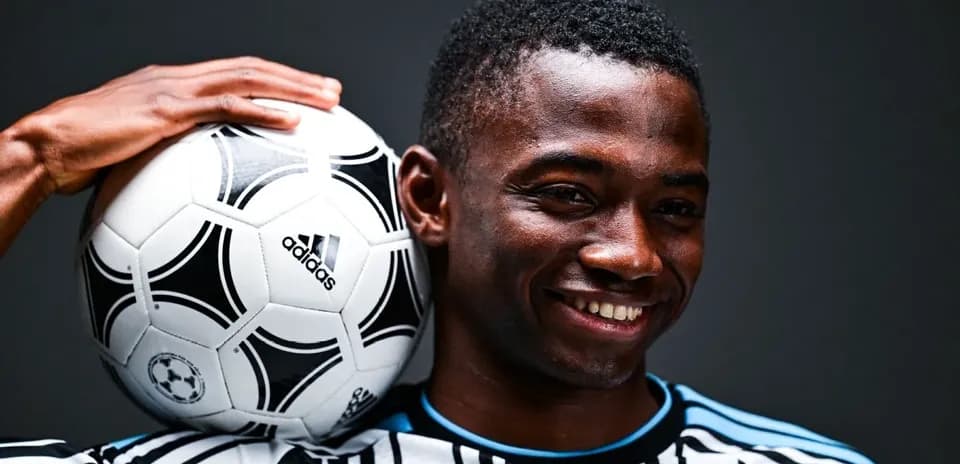 Jugador sosteniendo un balón de fútbol con una mano Jugador sosteniendo un balón de fútbol con una mano
