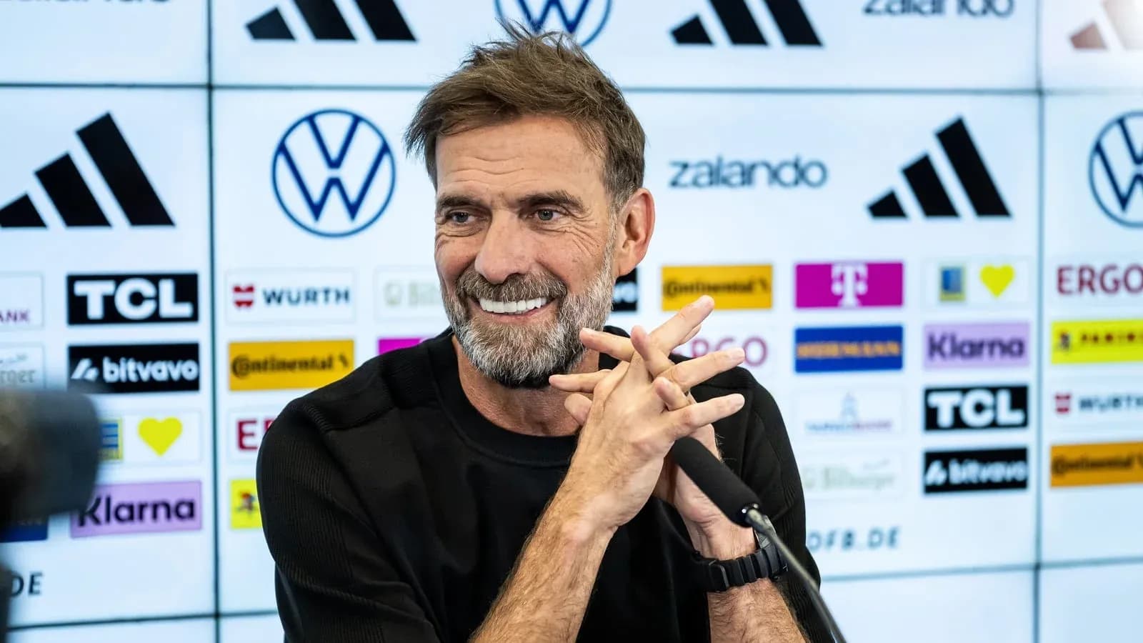 Entrenador en conferencia de prensa sonriendo Entrenador en conferencia de prensa sonriendo