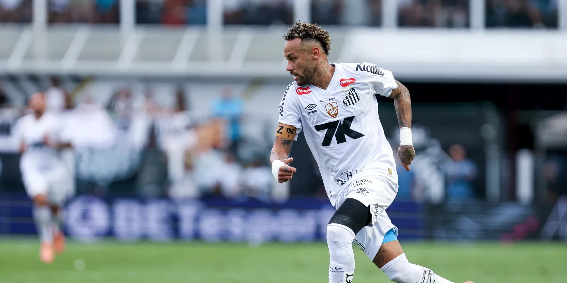 Jugador de Santos corriendo con el balón en campo Jugador de Santos corriendo con el balón en campo