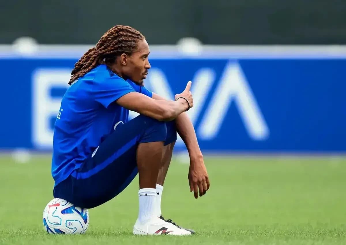 Jugador sentado en el campo con balón de fútbol Jugador sentado en el campo con balón de fútbol